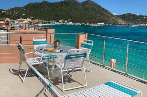 a table and chairs on a balcony with a view of the water at Sea Palace in Philipsburg