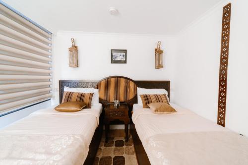two beds in a room with white walls at Saphir Dahabiya luxury sailing boat Nile cruise Every Saturday from Luxor 4 or 7 nights in Luxor