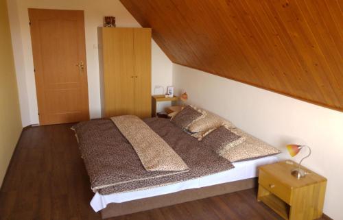 a bedroom with a large bed with a wooden ceiling at B&B Nika in Telč