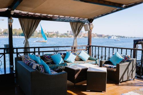 a balcony with couches and a view of the water at Saphir Dahabiya luxury sailing boat Nile cruise Every Saturday from Luxor 4 or 7 nights in Luxor