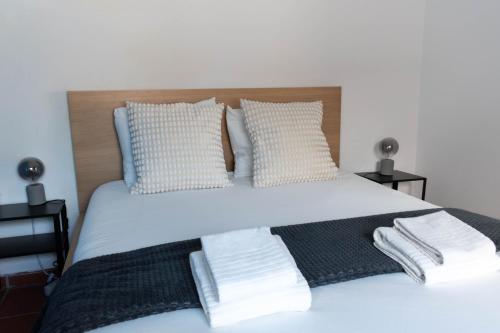 a bedroom with a white bed with two pillows at Casa Nº11 - Vila d'Óbidos in Óbidos