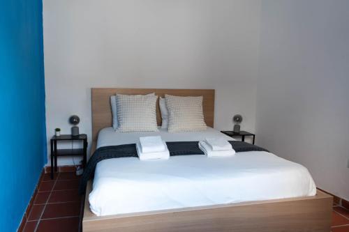 a bedroom with a large white bed with two pillows at Casa Nº11 - Vila d'Óbidos in Óbidos