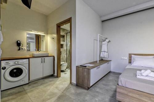 a bedroom with a bed and a washing machine at Studios Rosmari in Áyioi Pándes