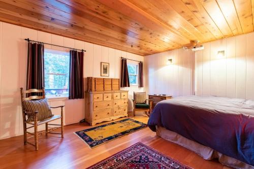 a bedroom with a bed and a wooden ceiling at Contemporary Classic on a Private Mountain Lake in Lake Arrowhead