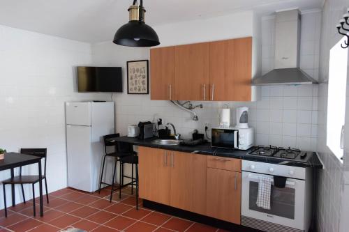 a kitchen with wooden cabinets and a stove top oven at Casa Nº11 - Vila d'Óbidos in Óbidos