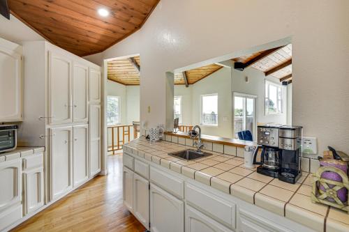 a large kitchen with white cabinets and a wooden ceiling at Aptos Home with Decks and Hot Tub - 2 Mi to Beach! in Aptos