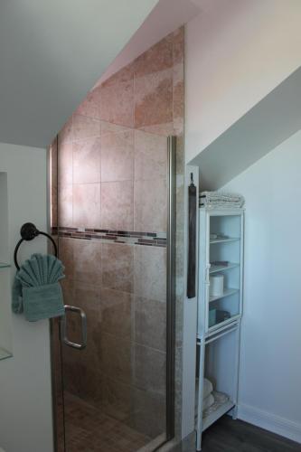 a shower with a glass door in a bathroom at Dungeness Barn House Bed and Breakfast at Two Crows Farm in Sequim