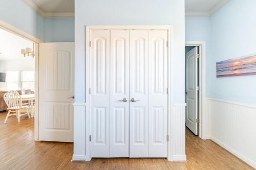 a room with white closet doors and a dining room at Central 2BR 2BA Easy Beach Access Sleeps 10 in Bolivar Peninsula