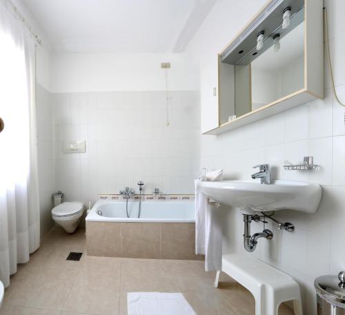 a bathroom with a tub and a sink and a toilet at Albergo Volpara in Mussolente 