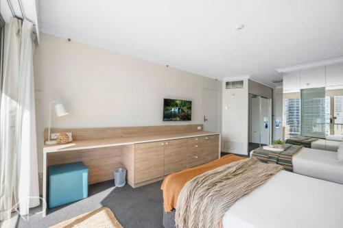 a bedroom with a bed and a desk and a couch at Bright Oceanview Apartment on Level 11, Mantra on View, Surfers Paradise in Gold Coast