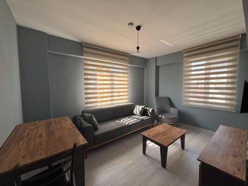 a living room with a couch and a table at Zeus Suit Görükle in Nilüfer