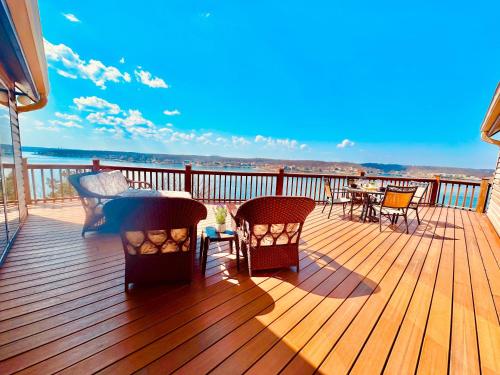 a wooden deck with a table and chairs on it at The Overlook At Cedar Point in Osage Beach