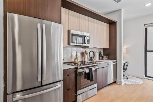 a kitchen with a stainless steel refrigerator and wooden cabinets at OTR 1 Bed Suite Free Parking Gym Pool Clubroom in Cincinnati