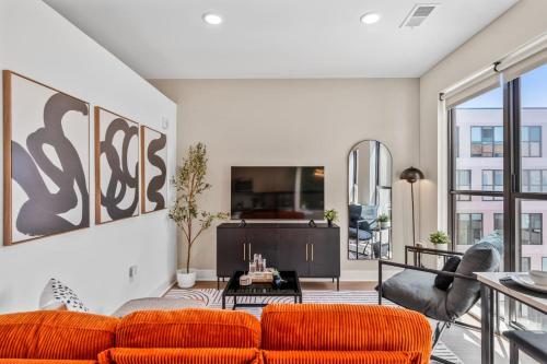 a living room with orange chairs and a couch at OTR King Bed Free Parking Gym Top Floor Club Room in Cincinnati
