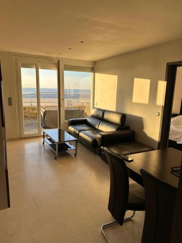 un salon avec un canapé et une table dans l'établissement Joli appartement Face Mer et Plage, Grande Terrasse panoramique, Berck Plage, à 15km du Touquet, à Berck-sur-Mer
