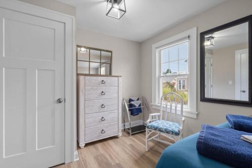 a bedroom with a dresser and a bed and a chair at 35 - Beautiful 3 BR Beach Haven in Old Lyme