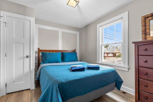 a bedroom with a bed with blue sheets and a window at 35 - Beautiful 3 BR Beach Haven in Old Lyme