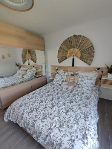 - une chambre avec un grand lit et deux miroirs dans l'établissement Appartement classé 3 étoiles à 150m de la plage, à Fréjus