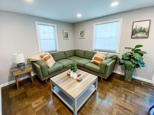 a living room with a green couch and a table at 21 COMFORTABLE AND LUXURIOUS in Plainville