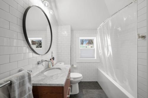 ein weißes Badezimmer mit Waschbecken und Spiegel in der Unterkunft Modern Heritage in Heart Halifax in Halifax