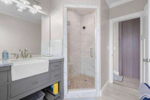 a white bathroom with a shower with a sink and a shower at 34- Stunning-Newly Remodeled in Old Lyme