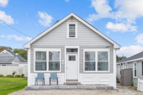 a white house with two chairs in front of it at 34- Stunning-Newly Remodeled in Old Lyme