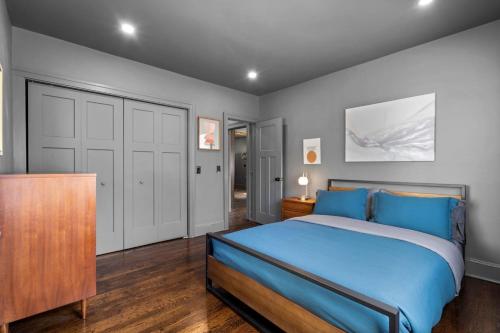 1 dormitorio con 1 cama azul y armario de madera en 28 - Modern Bungalow, en New Britain