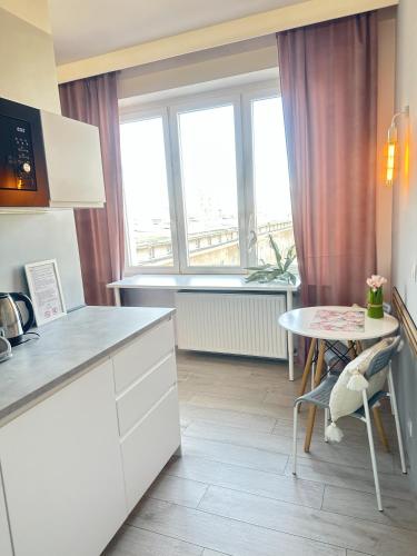 a kitchen with a table and a table and a window at Exclusive Apartments Smolna in Warsaw