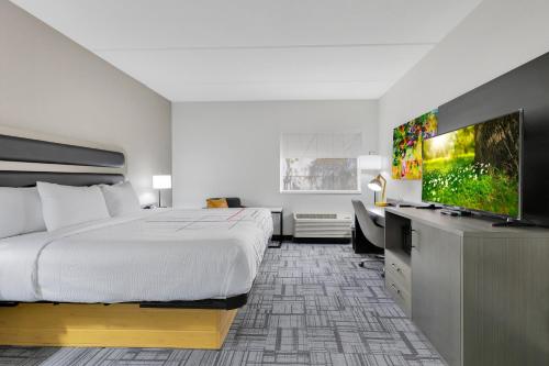 a hotel room with a bed and a flat screen tv at La Quinta Inn & Suites by Wyndham Jacksonville Mandarin in Jacksonville