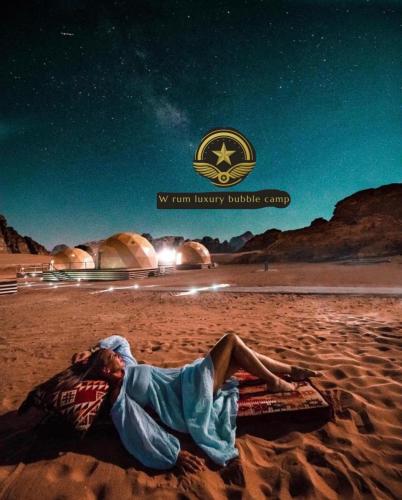 a man laying on the beach at night at RUM W BUBBLE lUXURY CAMP in Wadi Rum