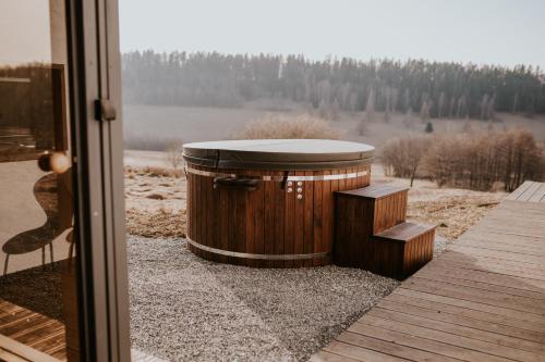 Eine hölzerne Wanne stand vor einer Tür. in der Unterkunft Kamienna Azyl - domek z sauną i balią, Kotlina Kłodzka in Kamienna