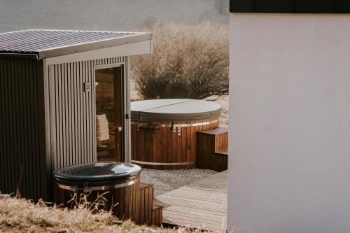 ein Gebäude mit zwei Whirlpools auf einer Terrasse in der Unterkunft Kamienna Azyl - domek z sauną i balią, Kotlina Kłodzka in Kamienna