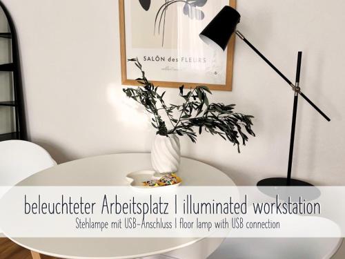 a white table with a vase with a plant on it at ApartNaest Radeberg - vollausgestattete 1 - 4 Zimmer Apartments I 24h flexibler mobiler Check-in via Link I Parkplatz auf Anfrage I Platz für bis zu 60 Personen in Radeberg