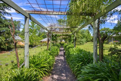a garden with a pergola and plants at Melview Greens - Two-Bedroom Apartment in Orange