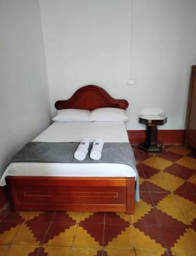 a bedroom with a bed with two slippers on it at La casa de la abuela in Jericó