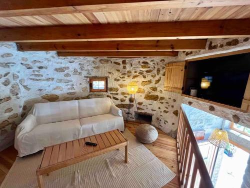 a living room with a white couch in a stone wall at The Mill - Sintra in Sintra