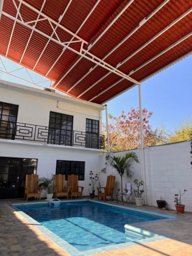an outdoor patio with a swimming pool and a pergola at Casa Vittorinos in Brisas de Zicatela