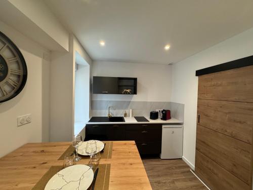 - une cuisine avec une table en bois et des verres dans l'établissement Le Cinéma des Amants, à Cholet