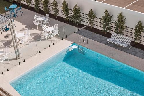 an overhead view of a swimming pool with chairs and tables at HotelMOTEL Adelaide in Adelaide