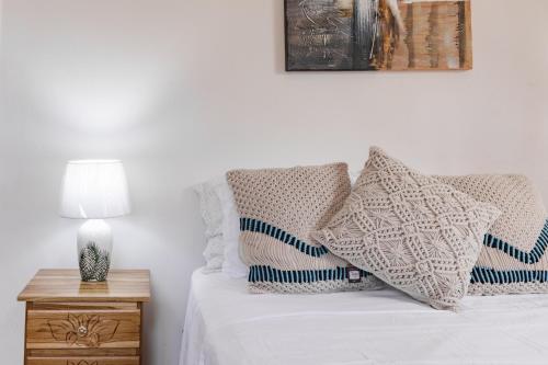 a white bed with pillows and a lamp on a night stand at One Bedroom House Punta Chame Club and Resort in Pajonal