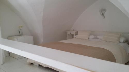 a white bedroom with a bed in a attic at Corte Moline in Gallipoli