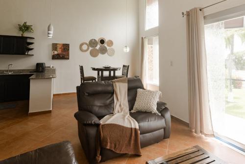 a living room with a leather chair and a table at One Bedroom House Punta Chame Club and Resort in Pajonal