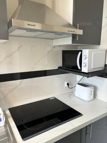 a kitchen with a counter top with a toaster and a microwave at Appartement entier HUI in Rueil-Malmaison