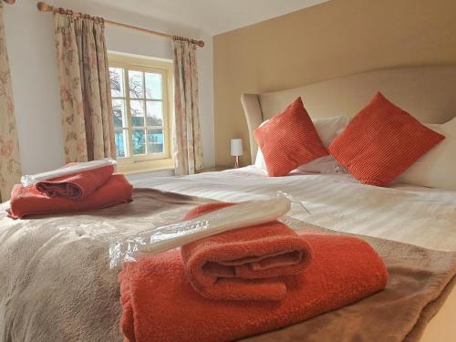 a bedroom with a bed with red towels on it at 1 Hope Cottage in Spilsby