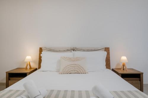 a bedroom with a white bed with two lamps at Casa di Olivo in Alykes