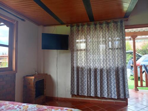 a room with a window with a curtain and a fireplace at Sol y Luna Villa Campestre in Iza