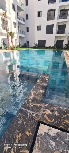 a swimming pool in front of a building at Élégance en 40 mètres Nouaceur in Nouaceur