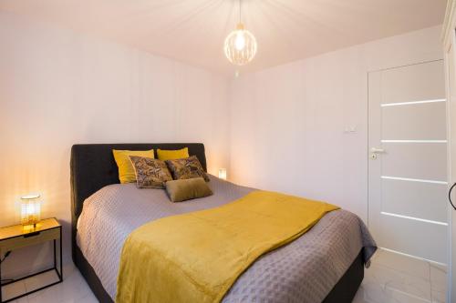 a bedroom with a bed with a yellow comforter at Apartament Golden Prestige in Głogów
