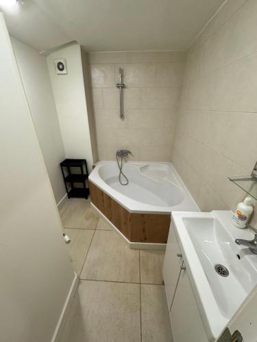 een witte badkamer met een bad en een wastafel bij Grand Duplex avec 2 chambres in Charleroi