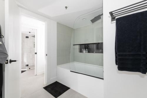 a white bathroom with a sink and a mirror at Bellio in Sobe in Miami Beach